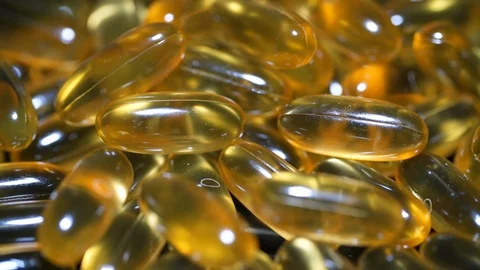 Cod liver oil omega 3 gel capsules isolated on black mirror surface dietary Stock Footage 111800815