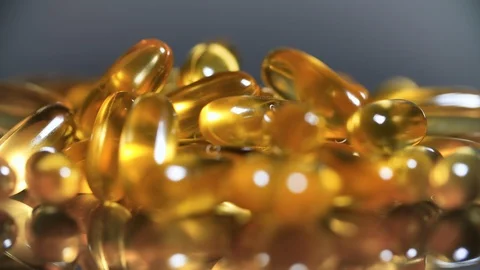 Cod liver oil omega 3 gel capsules rotation on black mirror surface Stock Footage 116231737