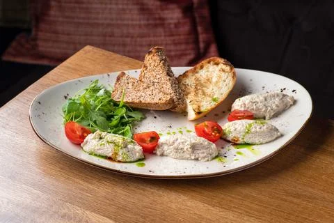 Cod liver pate with brown bread on plate. Homemade spread made from cod liver Stock Photos