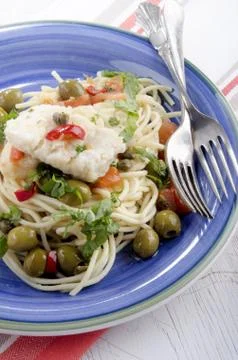 Cod with olive, caper, tomato and parsley Stock Photos