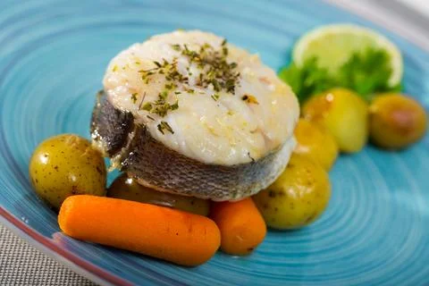 Cod by rustically frying and served with boiled potatoes, carrots and greens Stock Photos