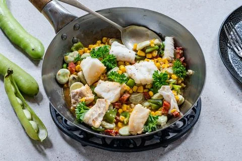 Cod, sweetcorn and broad beans succotash Stock Photos