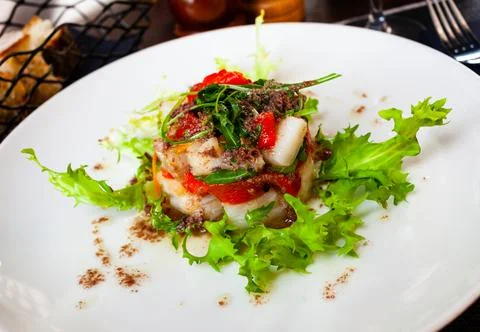 Cod timbale with roasted red peppers, rocket, olives Stock Photos