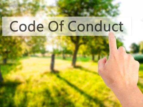 Code Of Conduct - Hand pressing a button on blurred background concept on vis Stock Photos