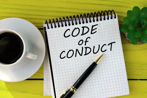 CODE of CONDUCT - words on a white sheet on a yellow wooden background with.. Stock Photos