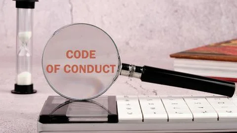 CODE OF CONDUCT words written through a magnifying glass on a calculator with Foto stock