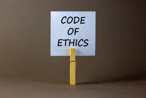 Code of ethics symbol. White paper with words 'Code of ethics', clip on wood  写真素材