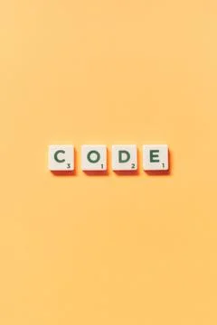 Code formed of scrabble blocks on yellow background. Stock-Fotos