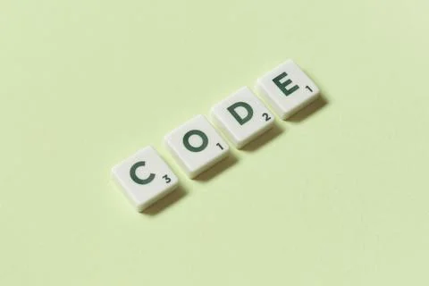 Code formed of scrabble elements on green background. Stock Photos