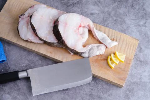 Codefish slices on marble bottom. Copy space. Fresh fish concept. Stock Photos