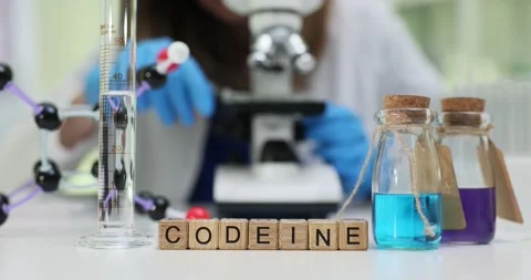 Codeine cubes on lab desk with glass flasks and scientific tools Stock Footage 314113716