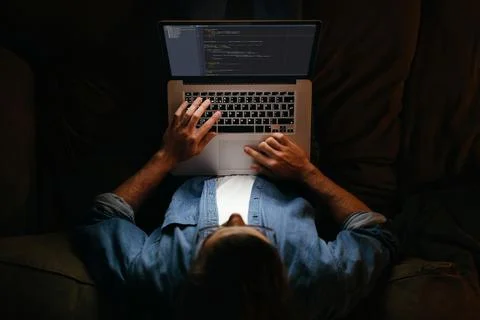 Coder in eyeglasses is working remotely from home Stock-Fotos