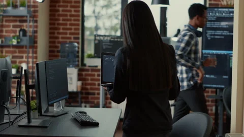 Coder holding laptop with coding interface entering software development agency Stock Footage 168252512