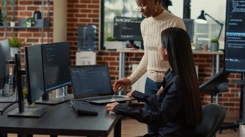 Coder holding laptop with coding interface entering software development agency Stock Photos