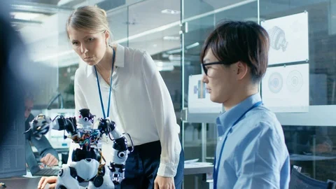 Coder Programmes Robot and Talks with Chief Engineer. Stock Footage 85772176