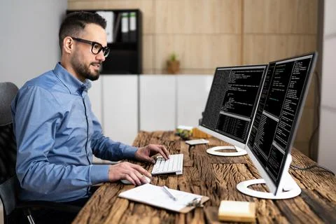 Coder Using Computer At Desk Stock Photos