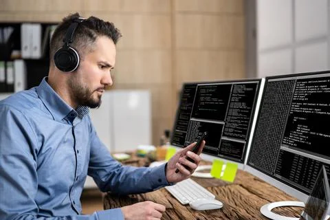 Coder Using Computer At Desk 库存照片