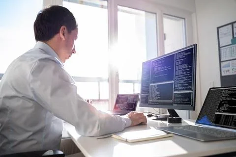 Coder Using Computer At Desk Stock Photos