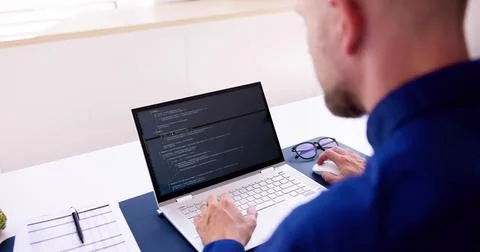 Coder Using Computer At Desk 写真素材