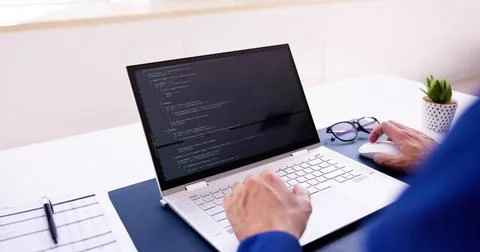 Coder Using Computer At Desk 库存照片