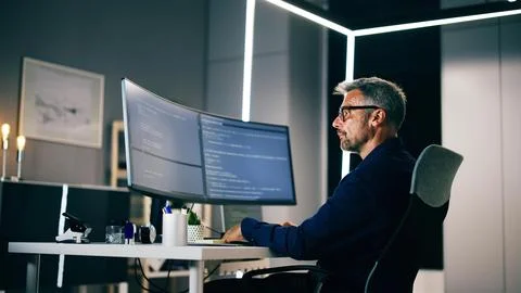 Coder Using Computer At Desk Foto stock
