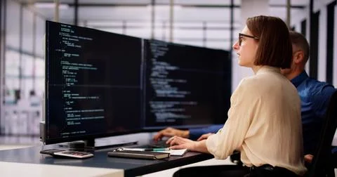 Coder Using Computer At Desk Foto stock