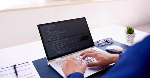 Coder Using Computer At Desk. Web Developer Stockfoto's