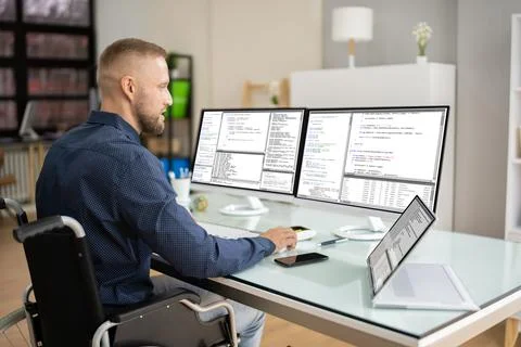 Coder In Wheelchair Using Computer Foto stock