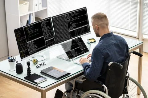 Coder In Wheelchair Using Computer Foto stock