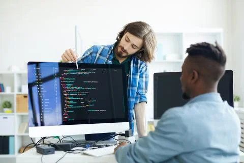 Coders discussing programming language Stockfoto's