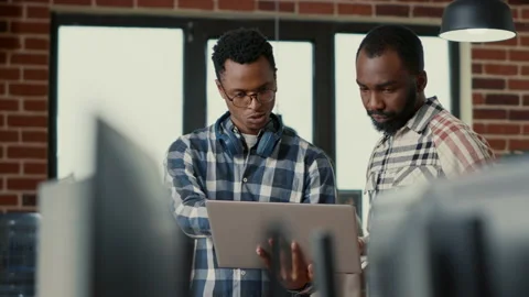 Coders talking about algorithms holding laptop pointing at sorce code on screen Stock Footage 168235489