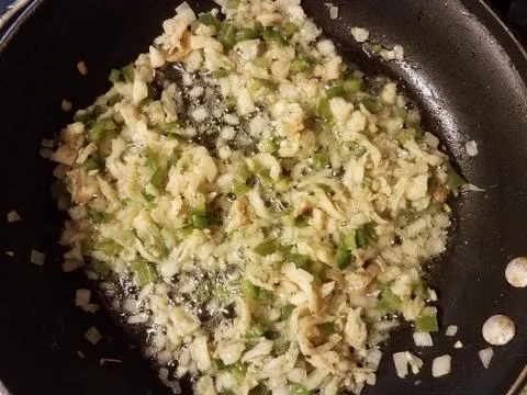 Codfish and green pepper and onion in frying pan Stock Photos