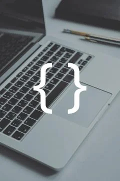 Coding and programming symbol on the background of a person typing on a lapto Stock Photos