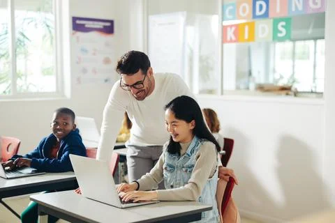 Coding class: Teacher guiding student with computer-based learning Stock Photos