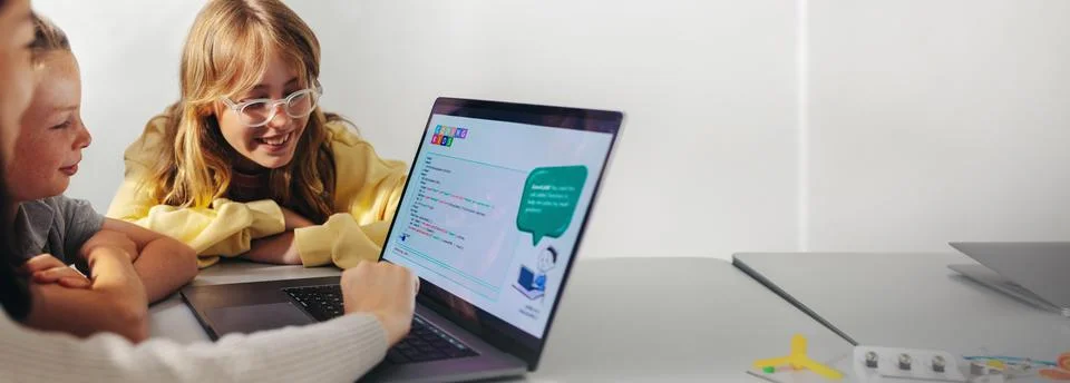 The coding classmates: Group of elementary school children learning how to .. Stock Photos