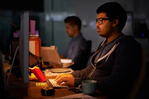 Coding, computer and night with programmer man at desk in office for cyber Foto stock