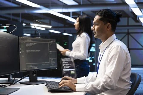 Coding, developer and coworker at server room workstation for programming Stock Photos