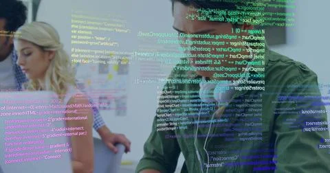 Coding developer wearing green shirt and earbuds at tech office desk, with Stock Photos
