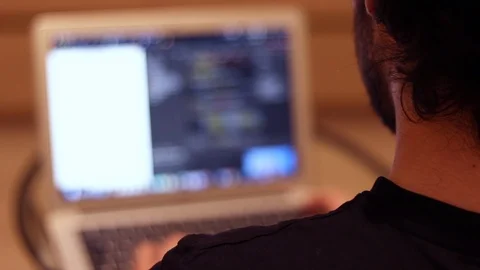 Coding guy sitting in front of his laptop and programming Stock Footage 121581845