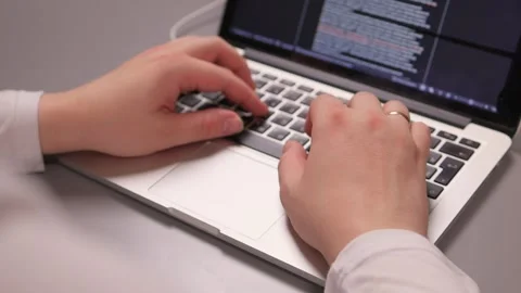 Coding hands work. Person in white sleeve entering commands on silver device Stock-Footage 347880182