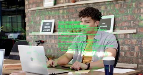 Coding man wearing gray shirt, yellow tee in co-working office, with laptop Stock Photos