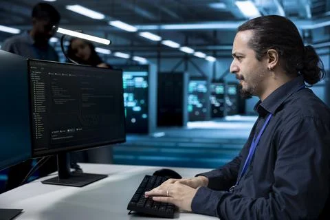 Coding, monitoring and developer at data center workstation Stock Photos
