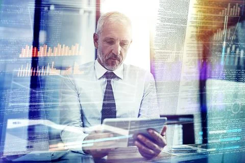 Coding on multiple platforms at once. a mature businessman working on Stock Photos