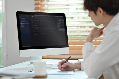 Coding programmer, software engineer sitting at desk, working in software Stock Photos