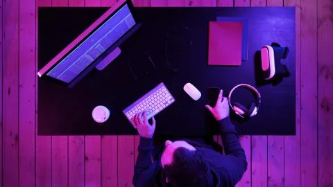 Coding specialist in casual with computer and talking by phone while coding Foto stock