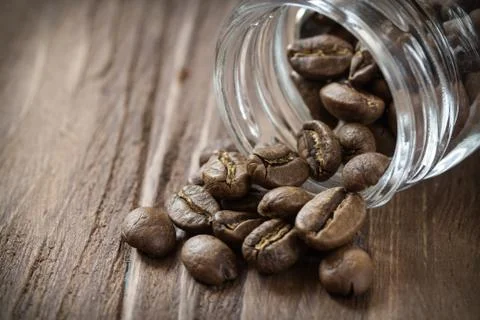 Cofee beans pulled out of glass jar Stock Photos