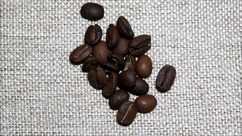 Coffe beans fall from top of bottom. A close up of a coffe beans. Stock Footage 128197816