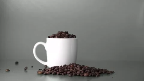 Coffe beans falling into white cup Stock Footage 140929667