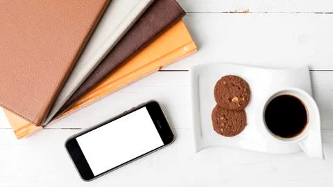 Coffe cup with cookie,phone and stack of book Stock Photos