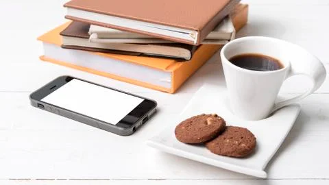 Coffe cup with cookie,phone and stack of book Stock Photos